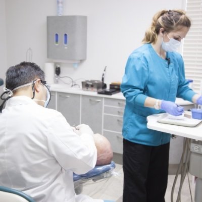 Dentist and dental team member treating dentistry patient