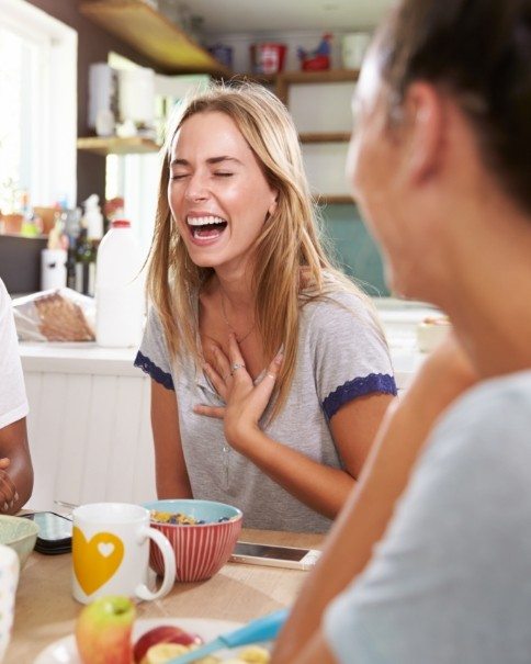 Woman laughing after receiving comprehensive dental services