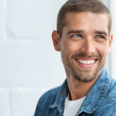 a man smiling after receiving new dental bridges