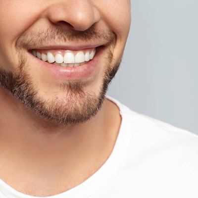 a man smiling after receiving new dental bridges