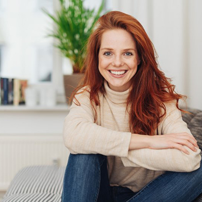 a woman smiling after receiving dental bridges