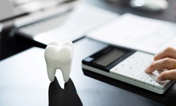Tooth sitting next to a calculator and some documents