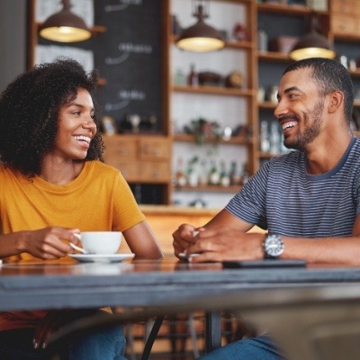 Man and woman sharing smiles after CEREC one visit dental crown restoration