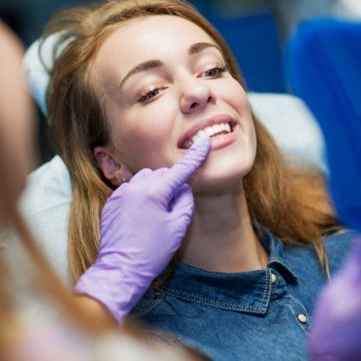 Dentist and patient examining smile after dental crown restoration