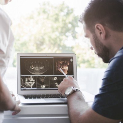 Dental team members reviewing digital x-rays and CEREC dental restoration design