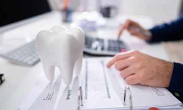 person calculating cost of dental crowns in Chesapeake