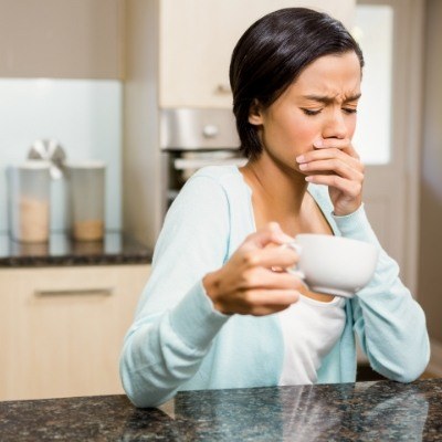 Woman in need of emergency dentistry experiencing heat sensitivity