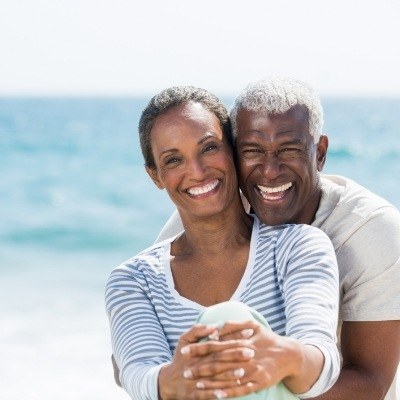 Man and woman smiling after dental implant failure and salvage