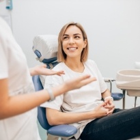 Woman smiling and talking to dentist