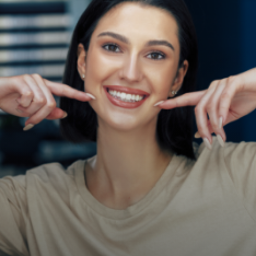 lady smiling and pointing to her smile
