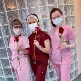 Three Chesapeake dental team members holding roses
