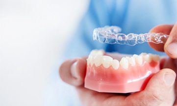 Placing Invisalign in Chesapeake Virginia on a model of teeth