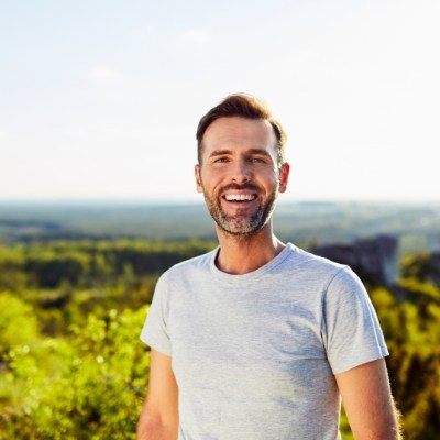 Man sharing flawless smile after replacing missing teeth