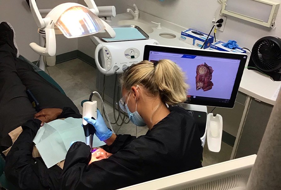 Dental team member and patient in dental exam room