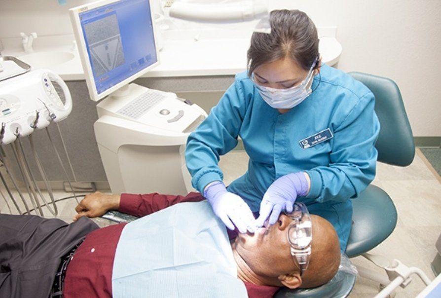 Dentist treating patient in dental exam room