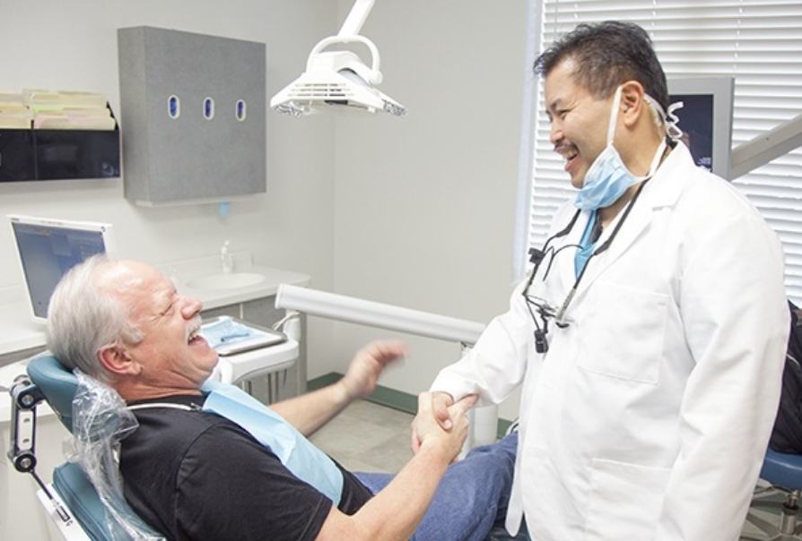 Dentist shaking hands with dental patient