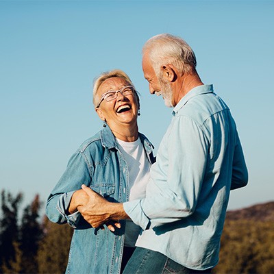 Older couple smiling after getting treatment by a BlueCross BlueShield dentist in Chesapeake