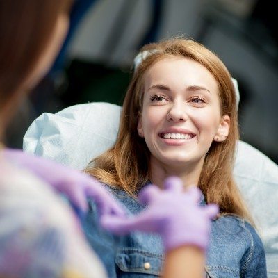 Woman smiling at dentist during Invisalign consultation