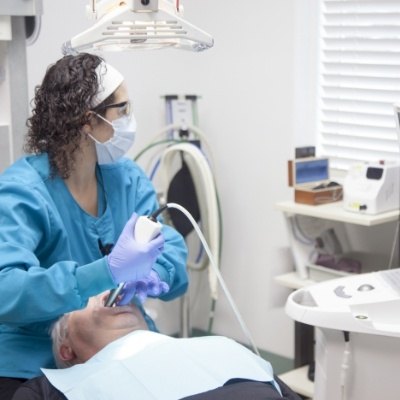 Dental team member capturing smile images using intraoral camera