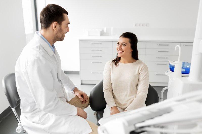 a patient smiling while visiting their dentist 