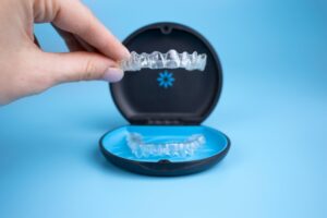 Hand holding a clear aligner.
