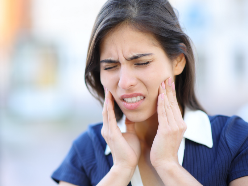 Woman holding face in pain